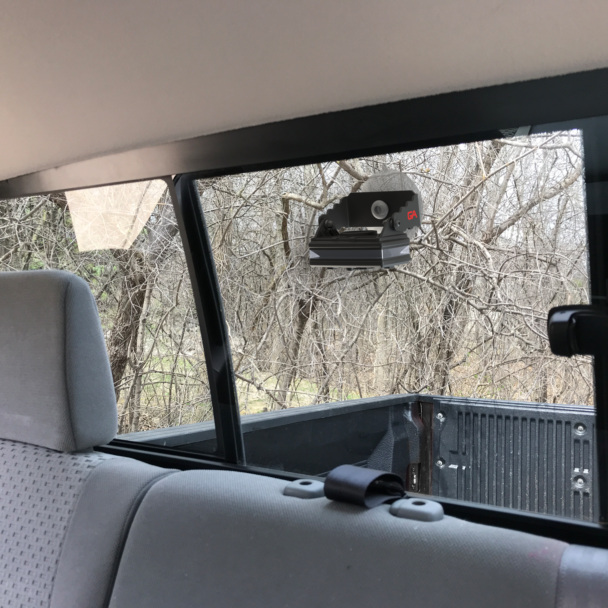 Guardian Angel Suction Cup mount with an Elite Series Safety light mounted on the inside of a back tuck window. The truck bed and leafless tree's populate the background.