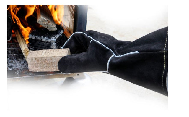 Person using Winnerwell Heat Resistant Gloves with a wood-burning stove.