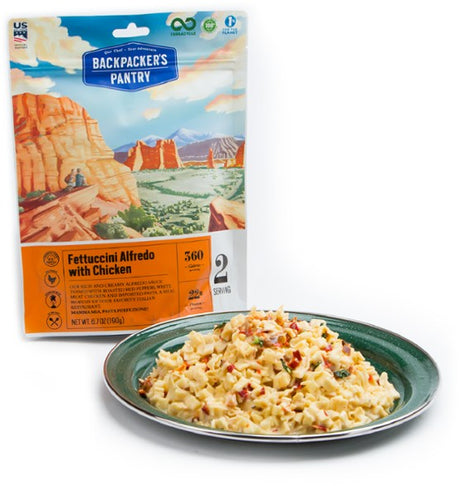 Backpackers Pantry- Fettucini Alfredo with Chicken package beside green dinner plate of the prepared food.