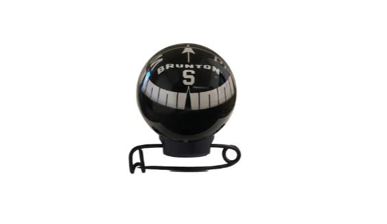 Brunton Mini Globe Compass attached on a pin in black with a reflective clear bulb.