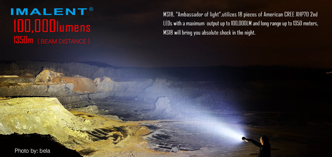 A person holding a Imalent 100,000 lumen MS 12 flashlight lighting up an entire field in front.