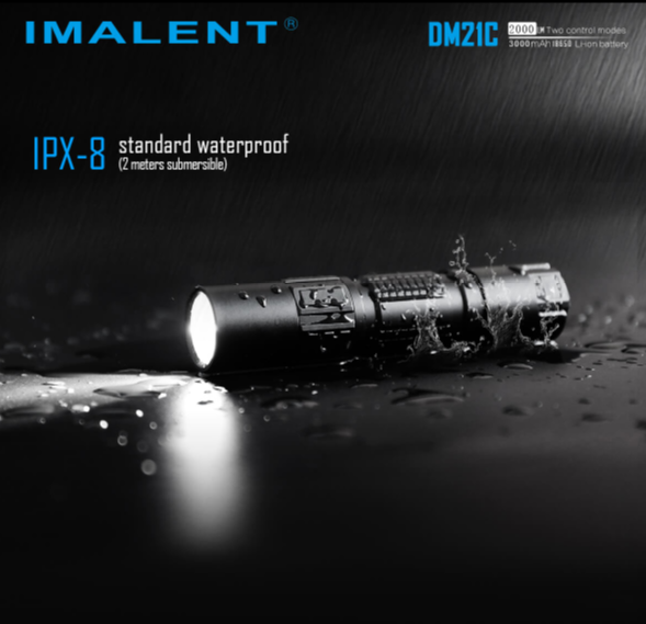 DM21C Flashlight being rained on, expressing it's IPx-8 waterproof rating with ability to submerge 2 meters. The flaslight is rested on a black surface with the light on and rain coming down on it.