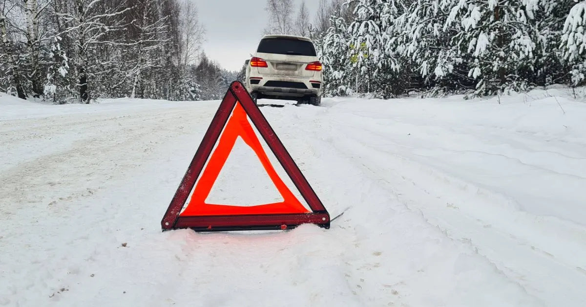 Car pulled over to the side of the road with a warning triangle signaling to other drivers to proceed with caution