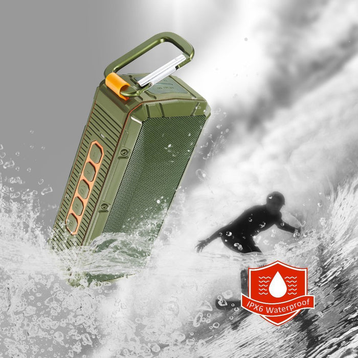 Kaito V3 Ruggedized IPX6 waterproof speaker with a surfer in the background, waves and water splash the speaker.