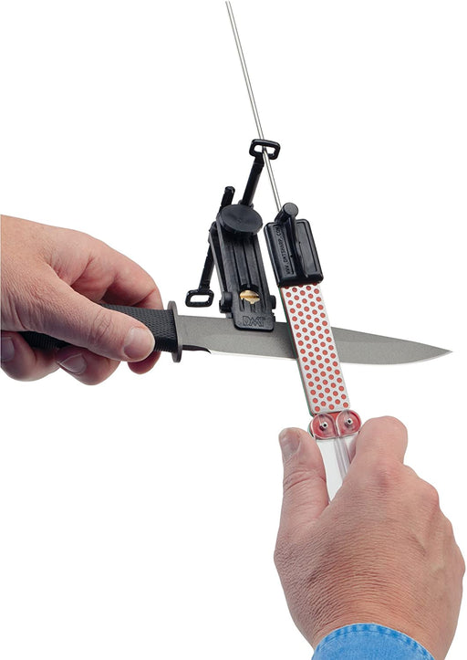 Person using the Diafold Magna Tool + Knife Sharpening Guide to sharpen a fishing knife. 