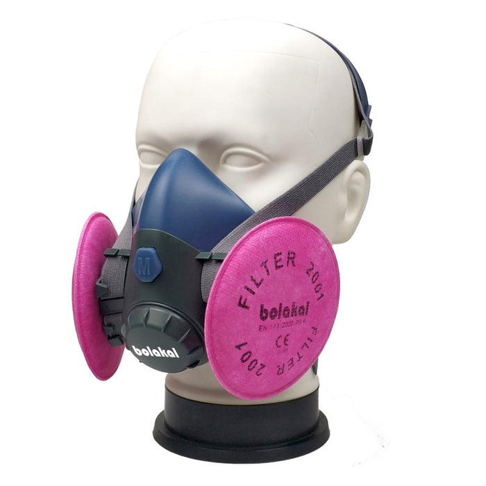 A bolakal face mask respirator on a mannequin with pink filters attached. The face mask is a navy blue colour with black straps.