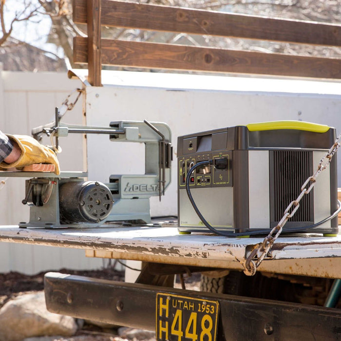 A worker using a powersaw on the bed of his truck and being powered by the Yeti 1400 portable power station.