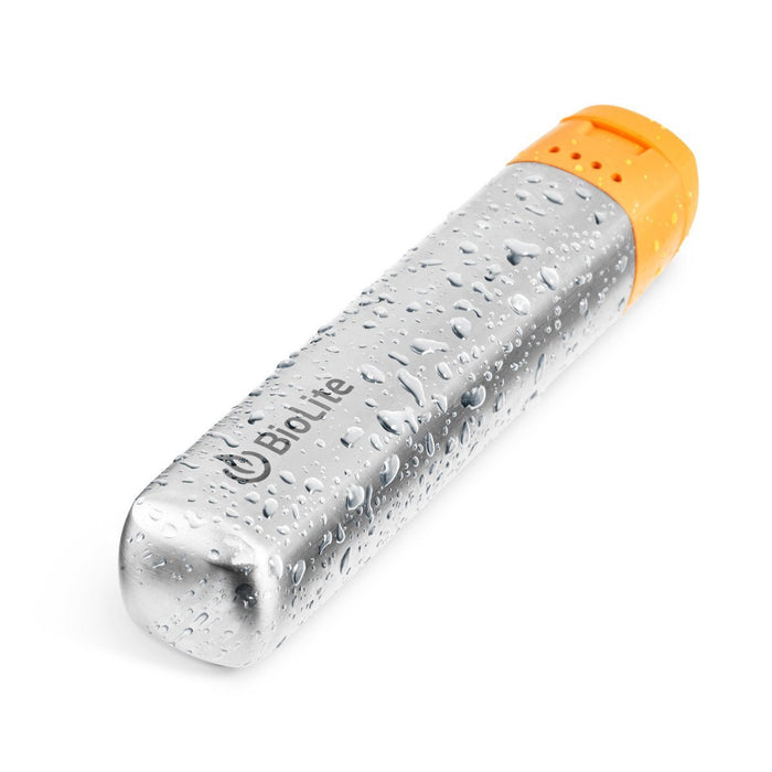 The Biolite Charge 10 2600mAh USB Power Bank with water splashed on top. The battery has an aluminium finish with an orange rubber cap at the top. The BioLite logo is on top side of the battery.