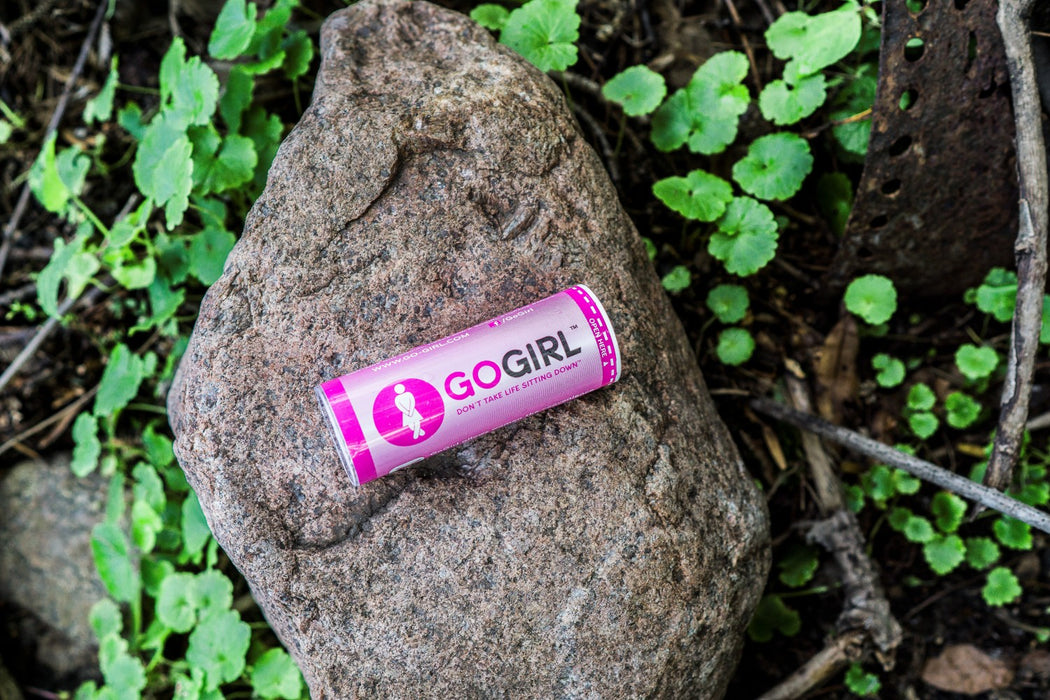 Go Girl Placed on a rock in the woods, surrounded by greenery.