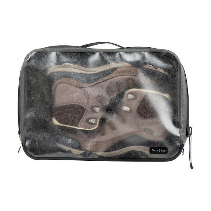 A pair of winter boots fit into a Nite-ize waterproof packing cube. The boots are brown with beige detailing.