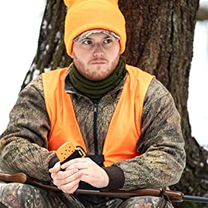 Orange Zippo Refillable Hand Warmer Being Used outside by a hunter wearing camo.