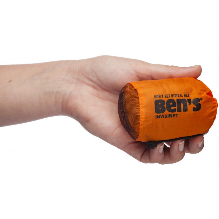 Hand cusped around Ben's Invisinet fold up bag in orange and black. 