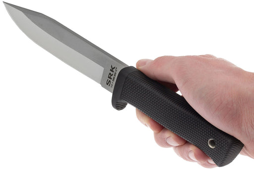 Person holding a Cold Steel Survival and Rescue knife and pointing it outward. The 'SRK' logo is printed on the blade and the finger guard is also shown on the knife handle.