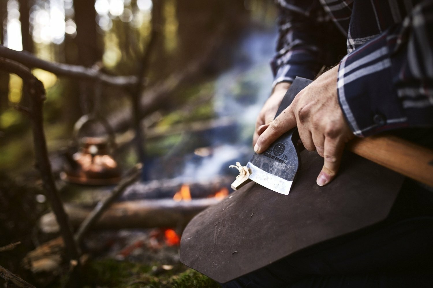 Hultafors Aby Forest Axe being used to create fire tinder outdoors by man wearing plaided shirt