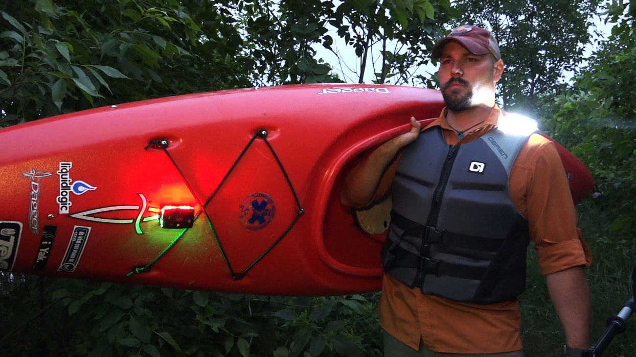 A Kayaker hauling his boat with two Guardian Angel Magnetic Mounts on his life jacket and Kayak.