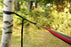A micro strap wrapped around a tree with the stainless steel rod holding the hammock loop which suspends the hammock off the ground.