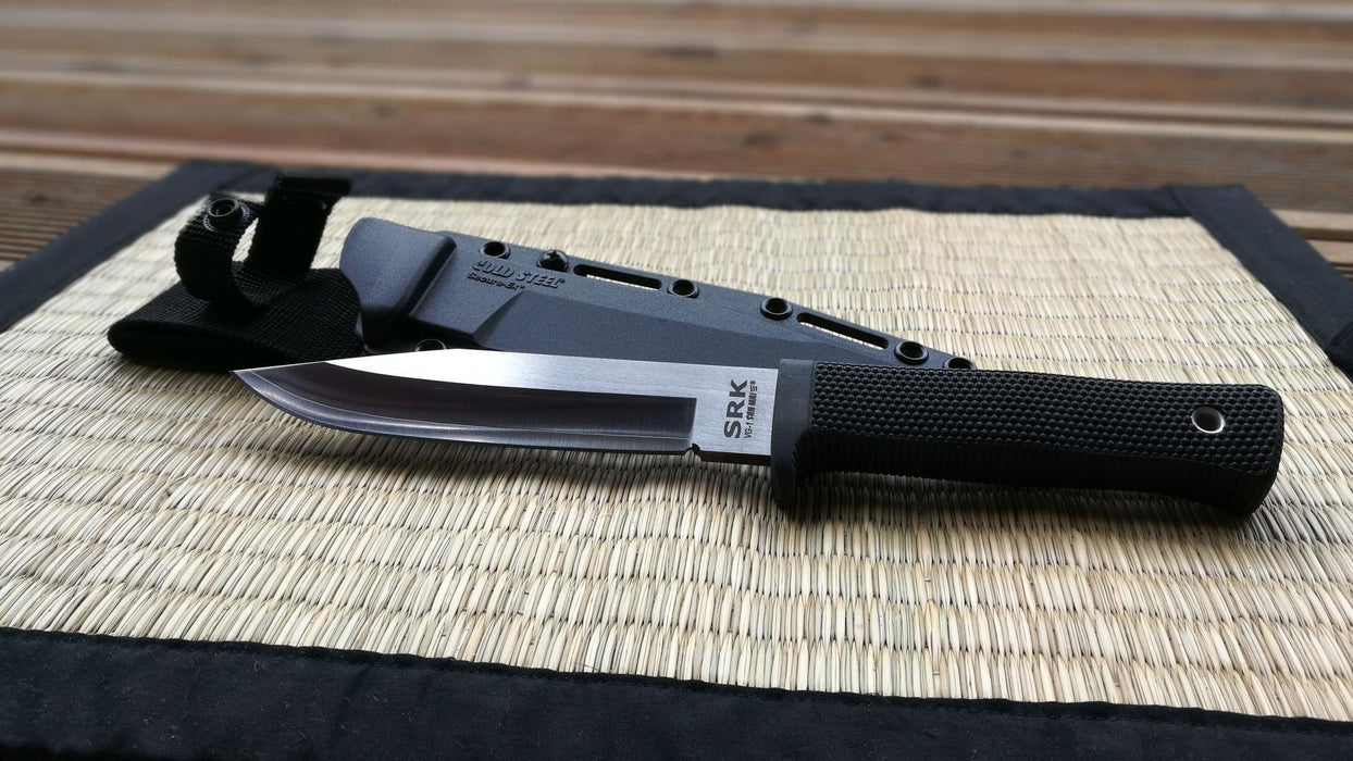 San Mai SRK knife with compatible sheath on a placemat. The 'SRK' logo is clearly shown on the blade of the knife.