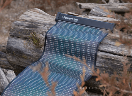 Lightsaver Powerfilm being laid out on a tree log in the outdoors. 
