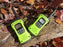 Two lime green and black Talkabout T600 Radios on a tree log in the fall. Leaves populate the surrounding area.