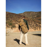 Man carrying Hazard 4 Evac Smuggler Padded Rifle Sling